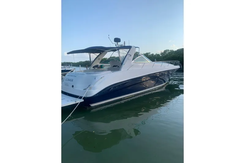 Sonata Yacht Photos Pics 1999 Sea Ray 460 Express Cruiser docked on calm water, side view.