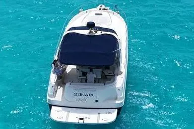 Sonata Yacht Photos Pics 1999 Sea Ray 460 Express Cruiser on clear turquoise water, rear view.