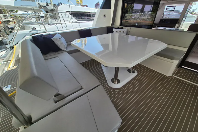 Tafika Yacht Photos Pics Luxurious seating area on 2024 Leopard 50 yacht with sleek table and cushions.