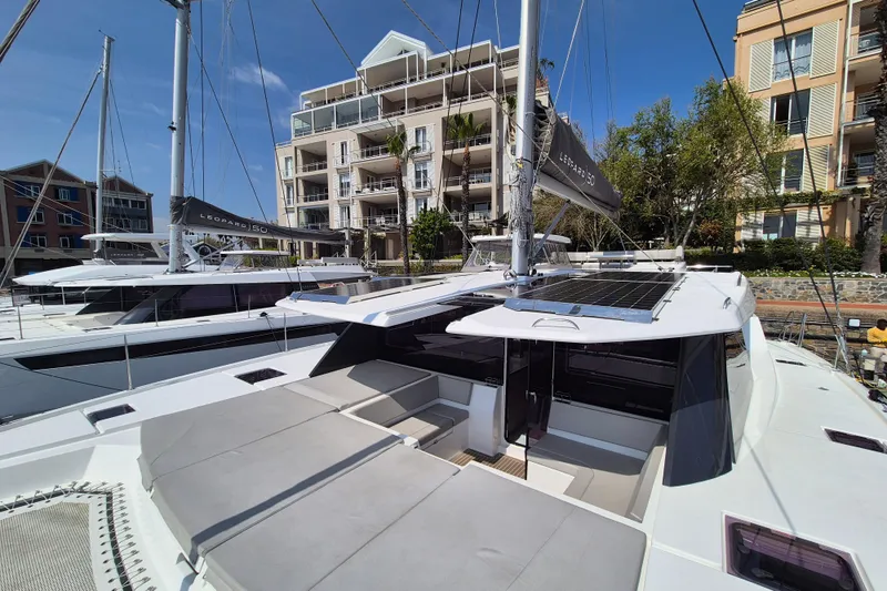 Tafika Yacht Photos Pics 2024 Leopard 50 yacht docked near modern waterfront buildings under clear blue sky.