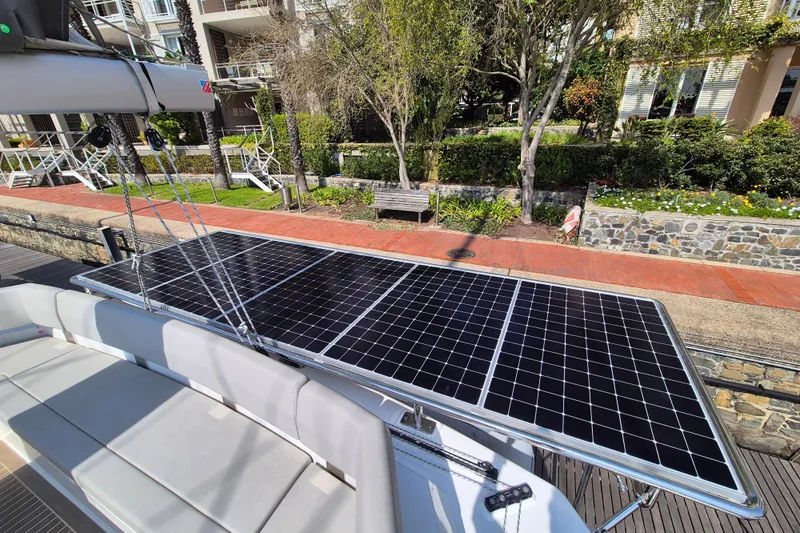 Tafika Yacht Photos Pics 2024 Leopard 50 yacht with solar panels docked near lush greenery.