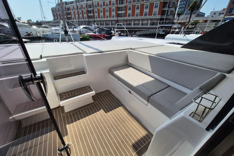 Tafika Yacht Photos Pics 2024 Leopard 50 yacht cockpit with cushioned seating and steps, docked at marina.