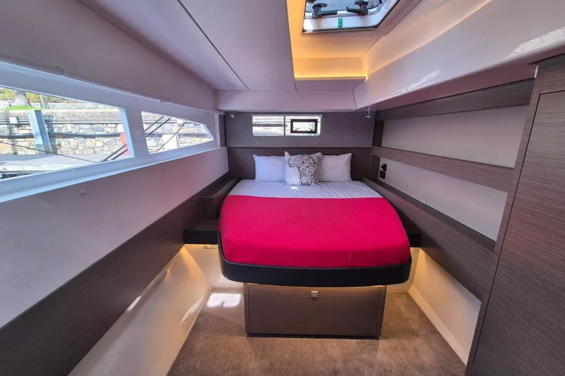 Tafika Yacht Photos Pics Luxurious 2024 Leopard 50 yacht cabin with modern design and vibrant red bedding.