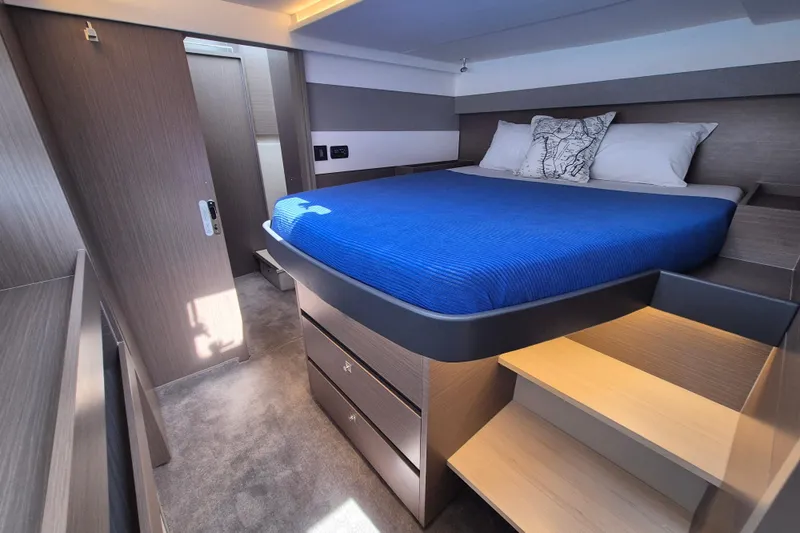 Tafika Yacht Photos Pics Luxurious 2024 Leopard 50 yacht bedroom with modern design and blue bedding.