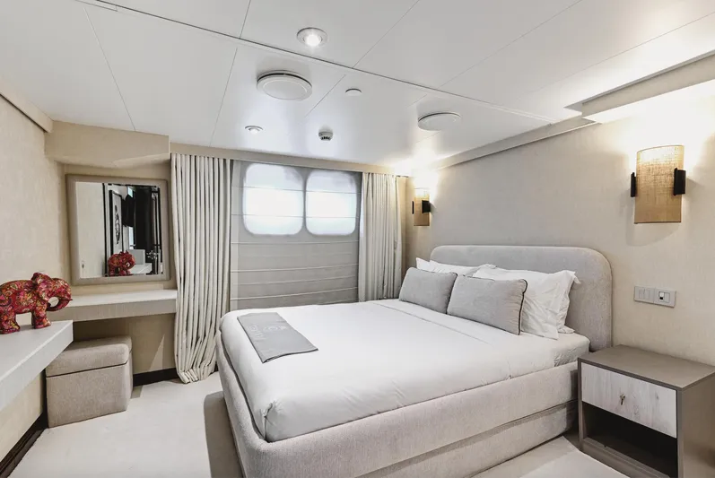 Chakra Yacht Photos Pics Luxurious yacht bedroom with modern decor, featuring a comfortable bed and elegant lighting.
