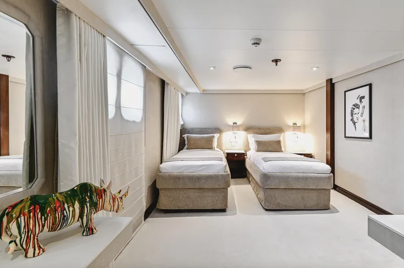 Chakra Yacht Photos Pics Luxurious yacht bedroom with twin beds, modern decor, and artistic rhino sculpture. Devonport 86m, 1963.