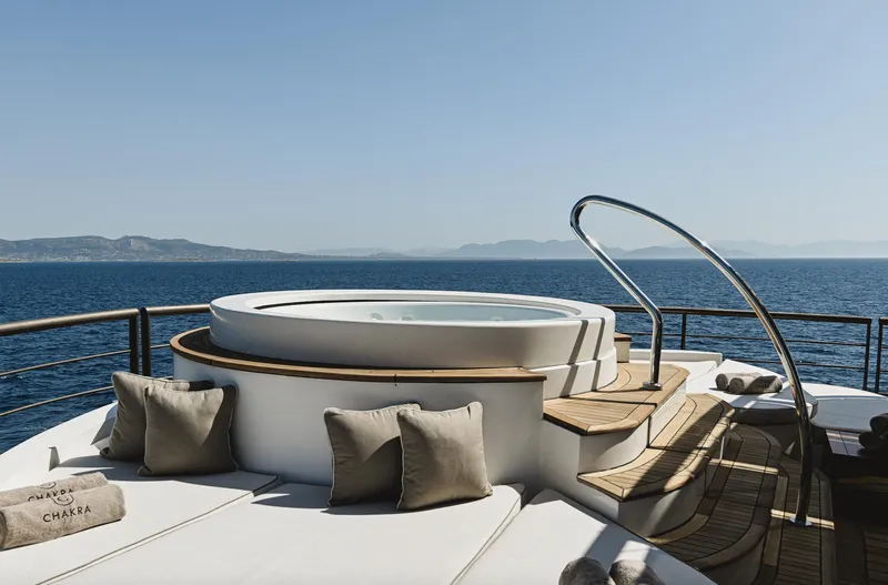 Chakra Yacht Photos Pics Luxurious yacht deck with hot tub, cushions, and ocean view; Devonport 86m, 1963 model.