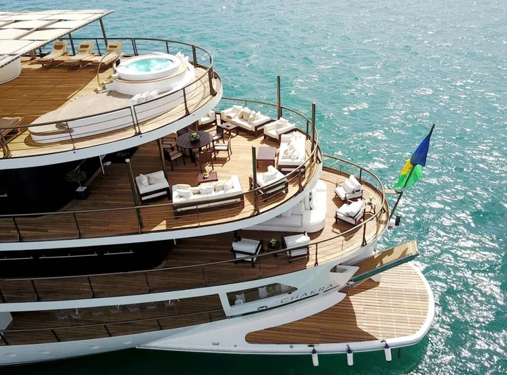 Chakra Yacht Photos Pics Luxurious Devonport 86m yacht with jacuzzi and seating, cruising on turquoise waters.