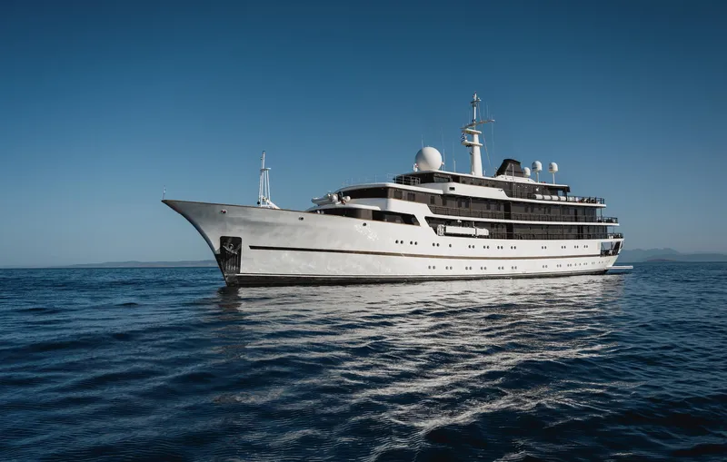 Chakra Yacht Photos Pics Luxurious Devonport 86m yacht from 1963 on calm blue sea under clear sky.