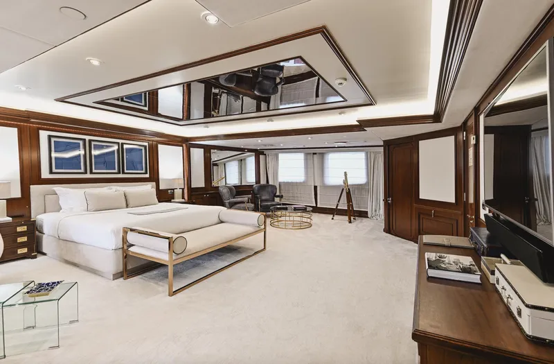 Chakra Yacht Photos Pics Luxurious yacht bedroom with elegant decor, featuring a large bed, wooden accents, and modern furnishings.