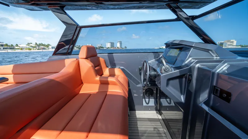 Pharmasea Yacht Photos Pics Luxurious 2022 Vanquish Yachts VQ45 interior with orange seating and modern dashboard on open water.