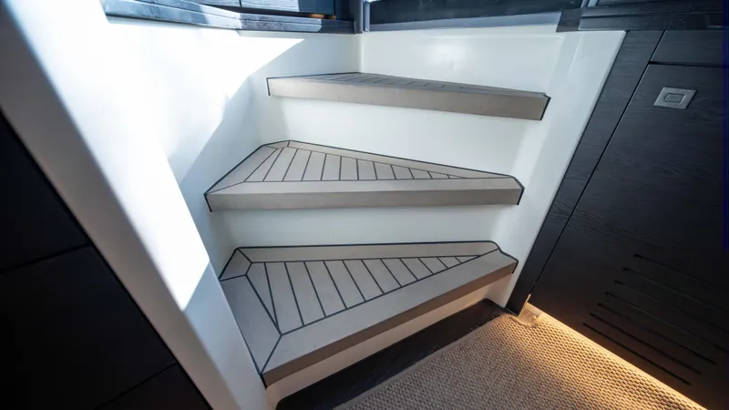 Pharmasea Yacht Photos Pics Modern interior stairs on 2022 Vanquish Yachts VQ45, featuring sleek design and ambient lighting.