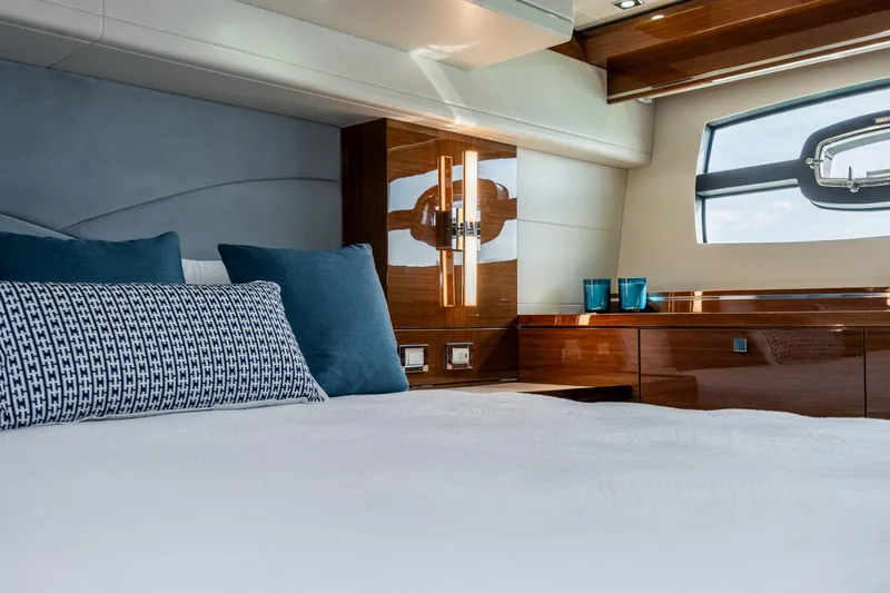  Yacht Photos Pics Luxurious bedroom interior of 2026 Neptunus 650F yacht with elegant wood finishes.