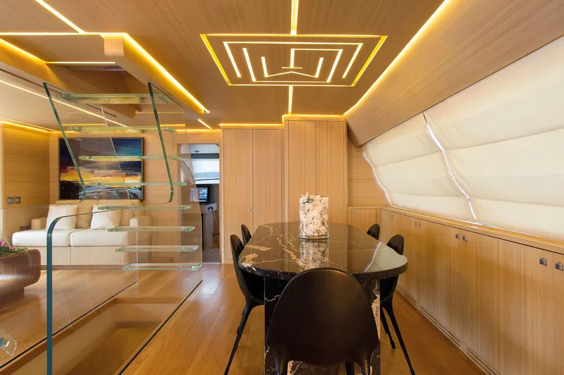 Ohana Yacht Photos Pics Luxurious interior of 2012 Fitzroy Yachts 49.7m, featuring modern dining area and elegant lighting.