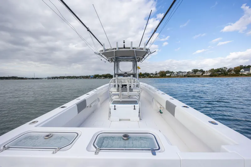  Yacht Photos Pics 2013 Contender 32 Tournament boat on calm water under cloudy sky.