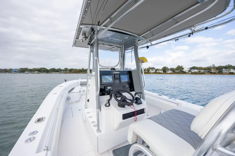  Yacht Photos Pics 2013 Contender 32 Tournament boat interior with steering console on calm water.