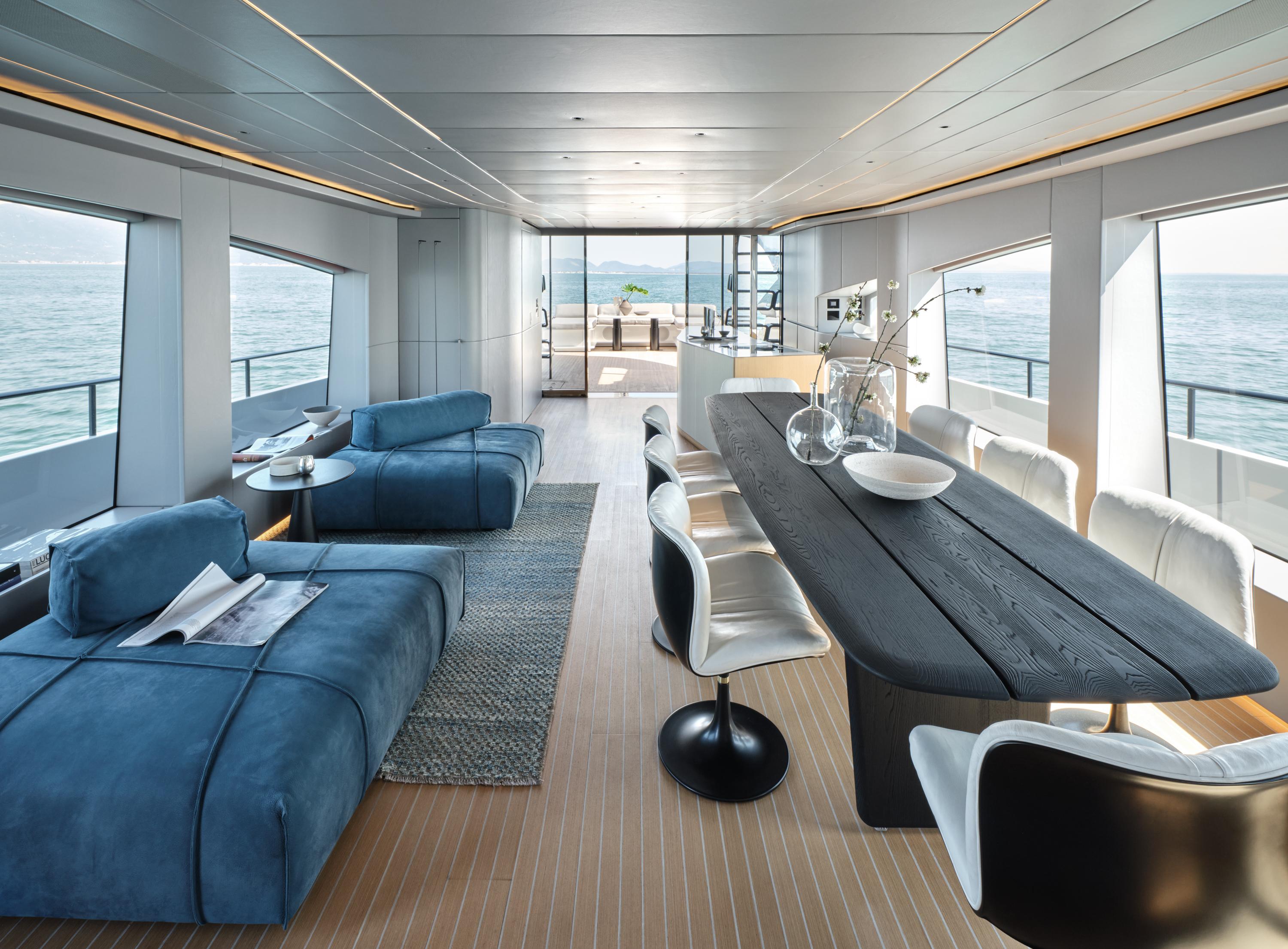 Luxurious yacht interior with modern furniture, panoramic ocean views, and elegant dining area. AB 110, 2025.