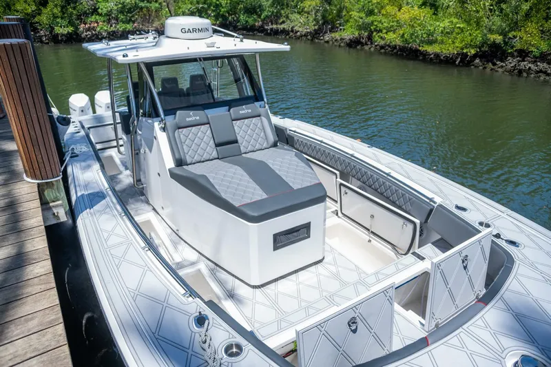  Yacht Photos Pics 2025 Sedna 37 Open boat with sleek design, docked by a lush riverside.