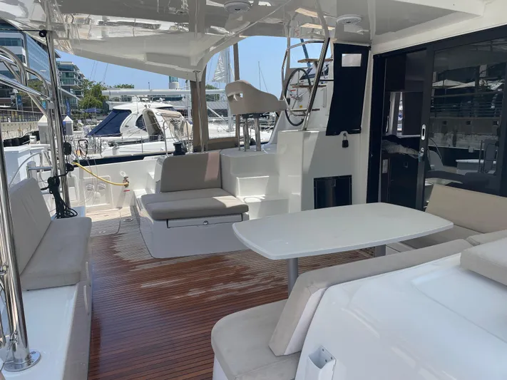 Hullchal Yacht Photos Pics 2021 Lagoon 42 yacht interior with seating and table, docked at marina.