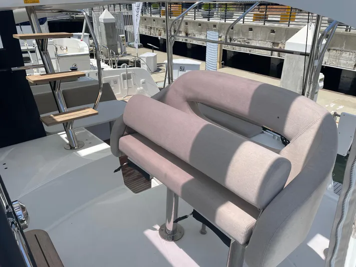 Hullchal Yacht Photos Pics 2021 Lagoon 42 yacht helm station with cushioned seating and wooden steps.