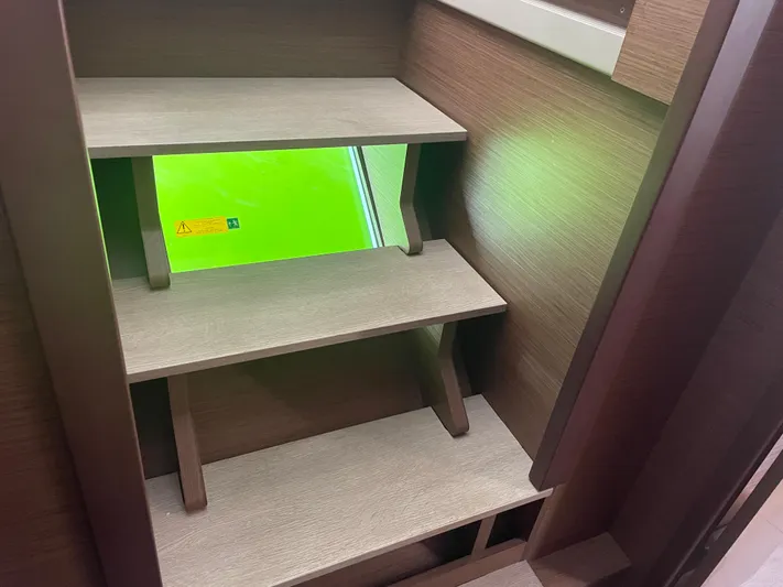 Hullchal Yacht Photos Pics Interior wooden steps on a 2021 Lagoon 42 yacht with a green window view.