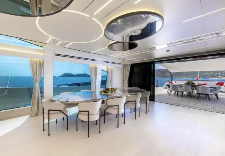 N1 Yacht Photos Pics Luxurious interior of 2022 Mangusta 165 REV yacht with elegant dining area and ocean view.
