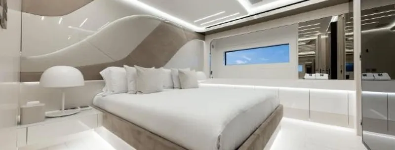 N1 Yacht Photos Pics Luxurious bedroom interior on 2022 Mangusta 165 REV yacht, featuring modern design and elegant lighting.