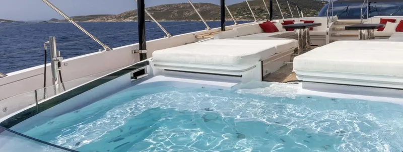 N1 Yacht Photos Pics Luxurious Mangusta 165 REV yacht deck with jacuzzi, sun loungers, and ocean view, 2022 model.