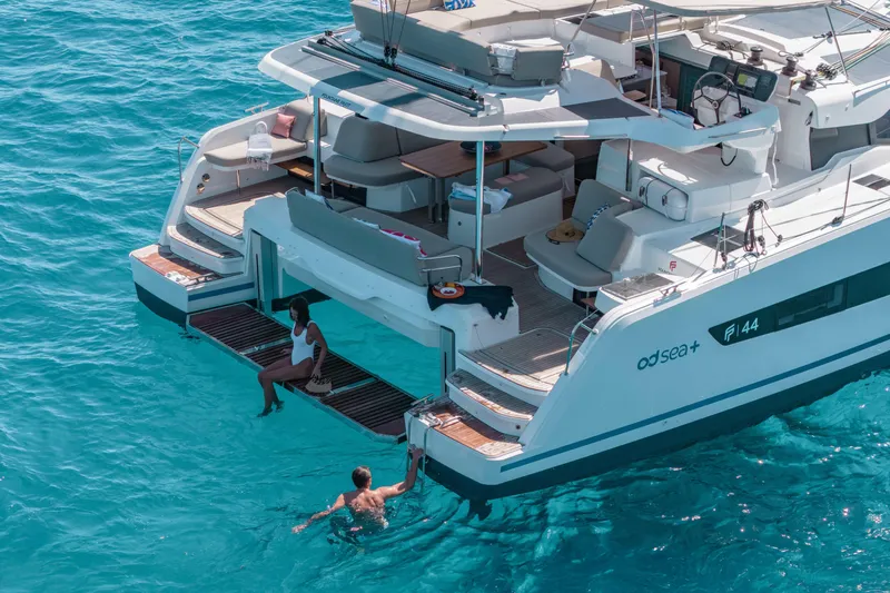  Yacht Photos Pics 2026 Fountaine Pajot FP 44 yacht on turquoise water, featuring a spacious deck and swimming platform.