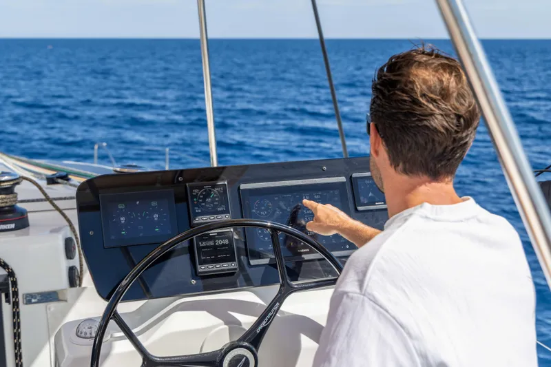  Yacht Photos Pics Man operating 2026 Fountaine Pajot FP 44 yacht's navigation system at sea.