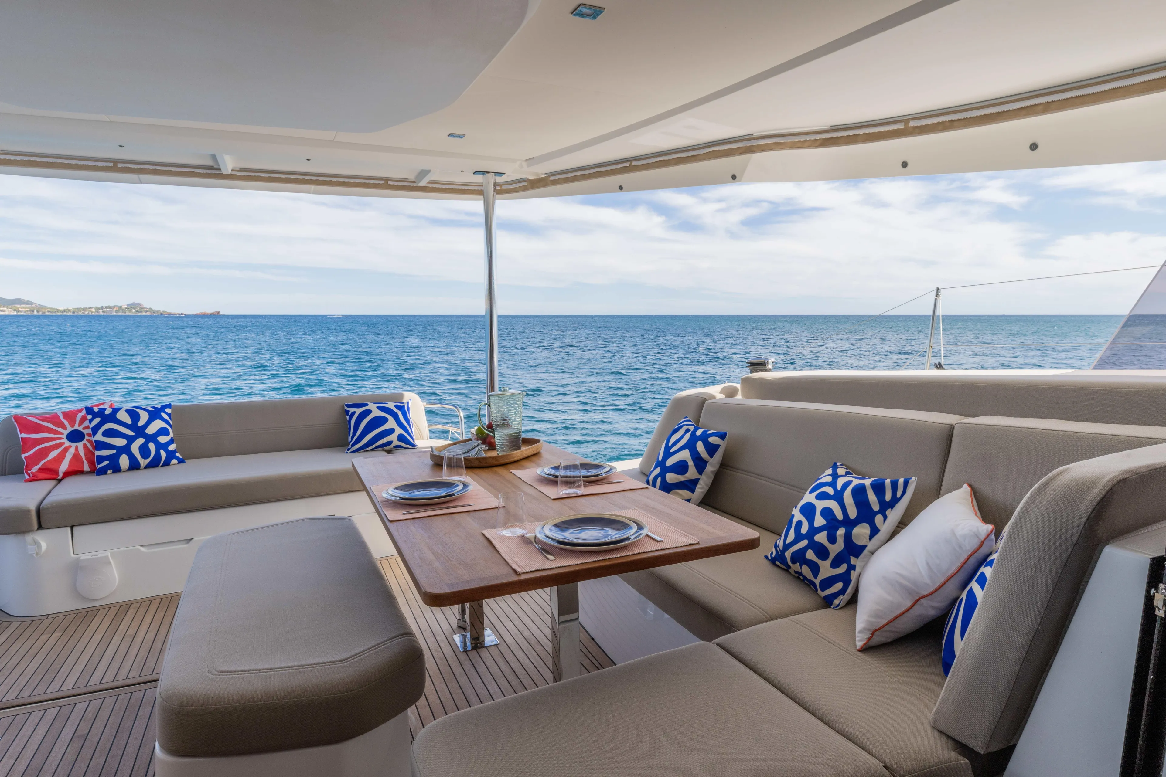  Yacht Photos Pics Luxurious 2026 Fountaine Pajot FP 44 yacht with elegant outdoor seating and ocean view.
