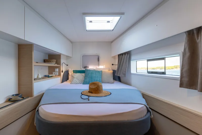  Yacht Photos Pics Luxurious cabin interior of 2026 Fountaine Pajot FP 44 catamaran with cozy bed and window view.