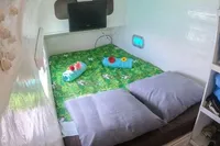 Cozy cabin interior of 2005 Marsaudon Composites T 50 Catamaran with bed, TV, and storage.