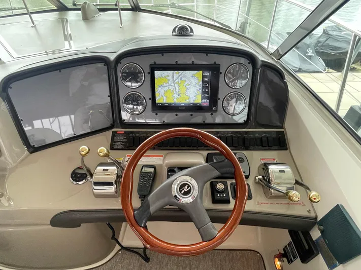 Knot Justified Yacht Photos Pics 2006 Sea Ray 38 Sundancer helm with navigation system and wooden steering wheel.
