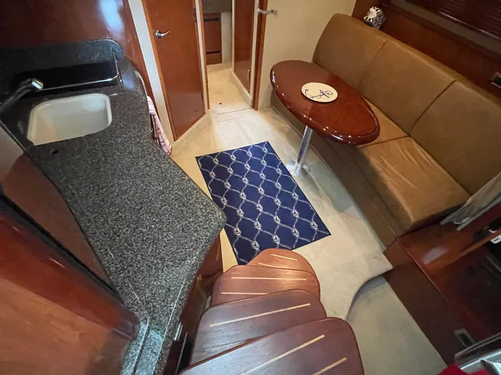 Knot Justified Yacht Photos Pics Interior of 2006 Sea Ray 38 Sundancer with kitchenette, sofa, and table.