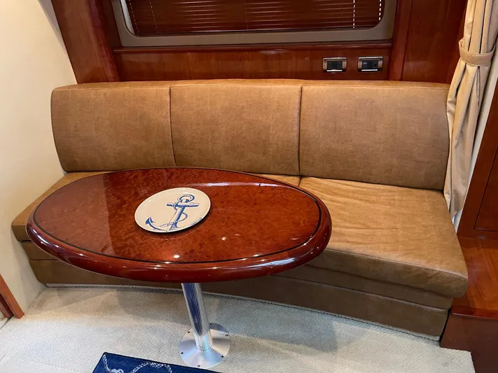 Knot Justified Yacht Photos Pics Interior of 2006 Sea Ray 38 Sundancer with brown sofa and oval wooden table.