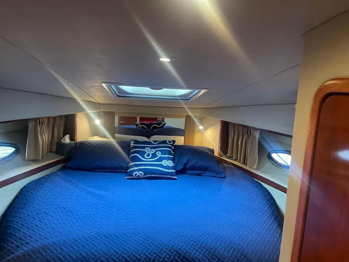 Knot Justified Yacht Photos Pics Interior cabin of 2006 Sea Ray 38 Sundancer with blue bedding and nautical decor.