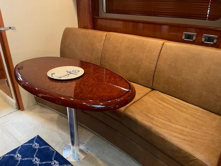 Knot Justified Yacht Photos Pics Luxurious interior of 2006 Sea Ray 38 Sundancer with elegant wood table and beige sofa.