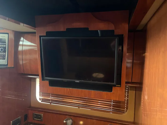 Knot Justified Yacht Photos Pics Flat-screen TV in 2006 Sea Ray 38 Sundancer yacht interior with wood paneling.
