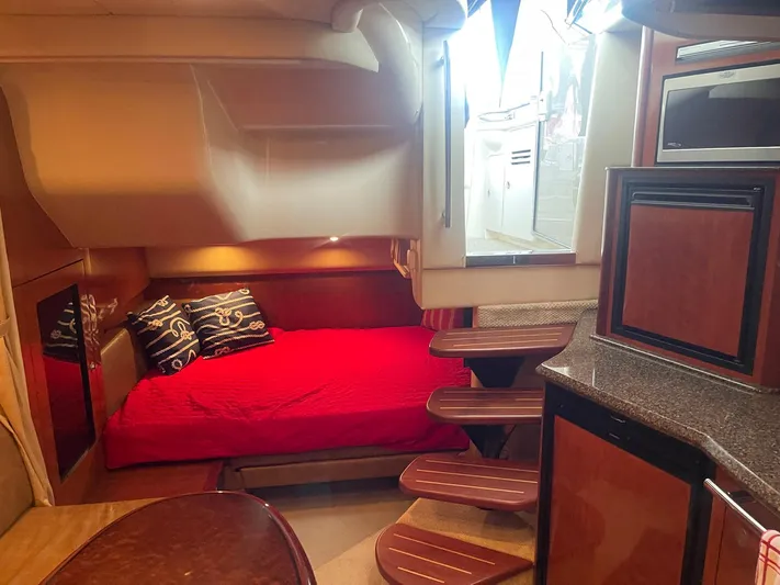 Knot Justified Yacht Photos Pics Interior of 2006 Sea Ray 38 Sundancer with red bedding and wooden cabinetry.