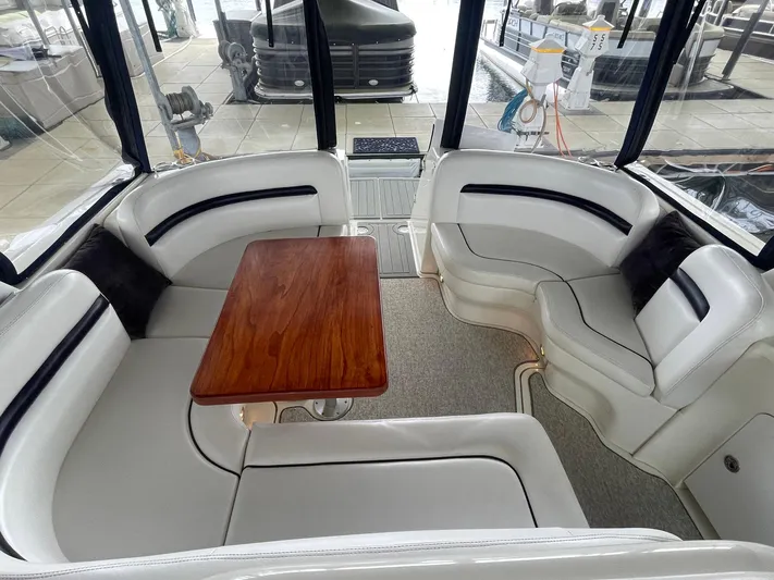 Knot Justified Yacht Photos Pics Interior of 2006 Sea Ray 38 Sundancer with white seating and wooden table.