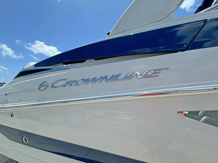  Yacht Photos Pics 2024 Crownline 290 XSS boat with sleek design under blue sky.