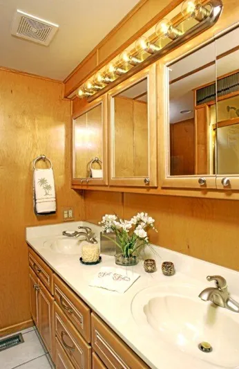  Yacht Photos Pics 2002 Stardust Cruisers houseboat bathroom with double sinks and wooden cabinetry.