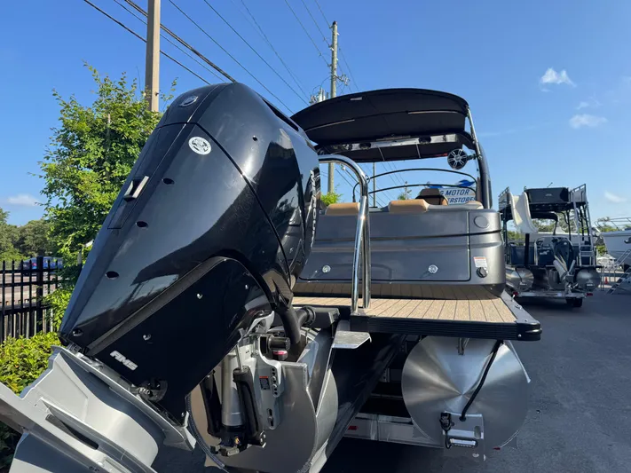  Yacht Photos Pics 2025 Avalon Excalibur 27' boat with powerful outboard motor, docked under clear blue sky.