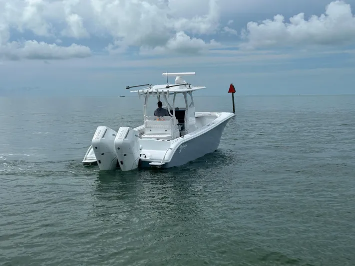  Yacht Photos Pics 2025 Yellowfin 32 boat cruising on calm ocean waters under cloudy skies.