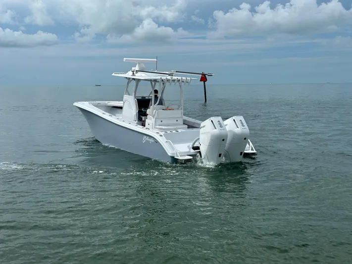  Yacht Photos Pics 2025 Yellowfin 32 boat cruising on calm ocean waters under cloudy sky.