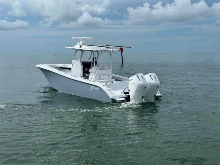  Yacht Photos Pics 2025 Yellowfin 32 boat on calm water under cloudy sky.