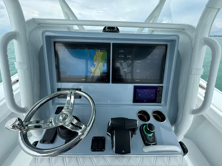  Yacht Photos Pics 2025 Yellowfin 32 boat dashboard with dual screens and steering wheel.
