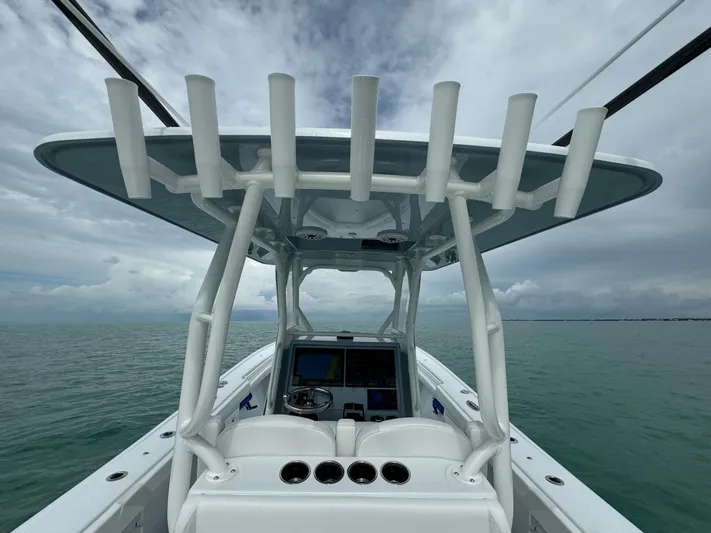  Yacht Photos Pics 2025 Yellowfin 32 boat console with rod holders on a cloudy day.