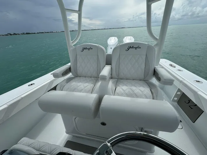  Yacht Photos Pics 2025 Yellowfin 32 boat interior with white cushioned seats on open water.